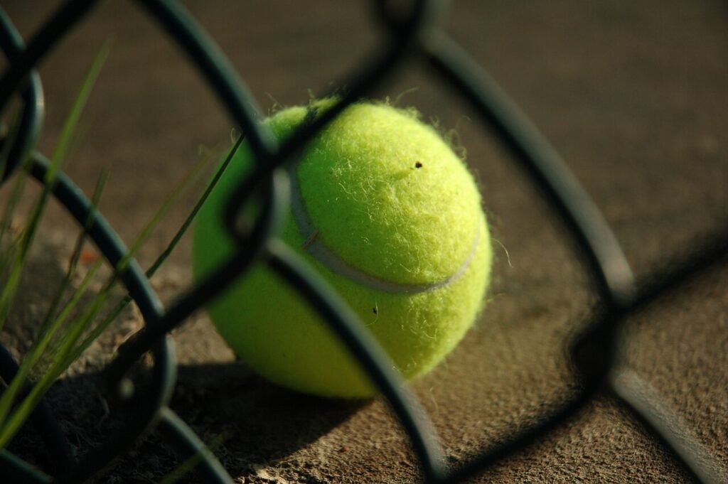Why are tennis balls fuzzy? Close-up of the felt fibers on a yellow tennis ball